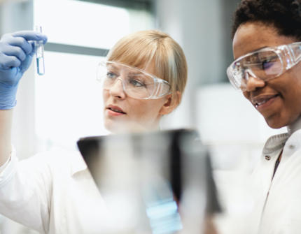 Two laboratory technicians, one of them is looking to a sample